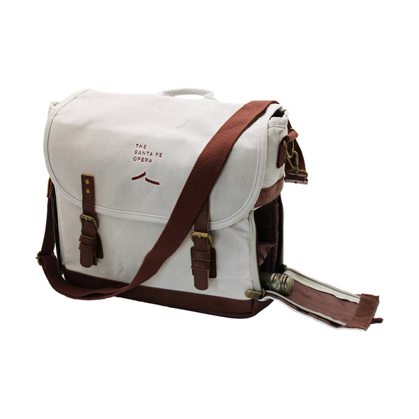 Image of an off-white canvas tote bag with brown accents and wine bottle pocket on the side.