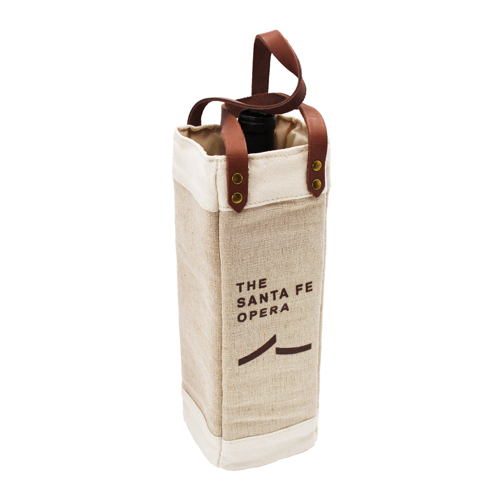Image of a beige canvas wine bag with brown handles and a brown Santa Fe Opera logo. Bag contains a single wine bottle.