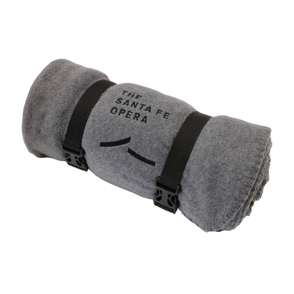 Grey fleece blanket with Black embroidered Santa Fe Opera logo. Black clipping handle.